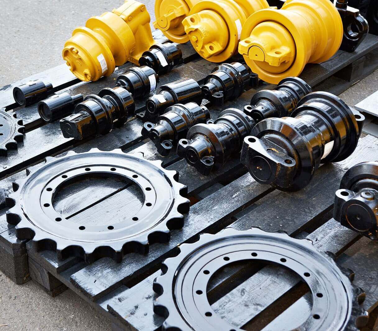 Industrial machinery parts including gears, shafts, and hydraulic components arranged on a surface.