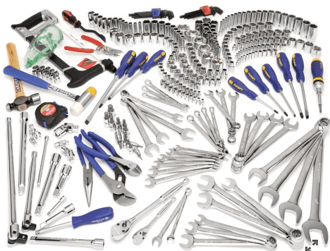 A large assortment of hand tools arranged on a white surface.